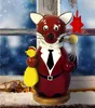 A decorative fox figurine with a pipe and a chick, placed on a windowsill with a snowy background. Produktbild-Vorschau
