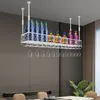 A white metal wine rack with bottles and wine glasses hanging from the ceiling in a dining room. Podgląd zdjęcia produktu