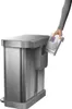 A hand is shown inserting a trash bag dispenser into a stainless steel trash can. Podgląd zdjęcia produktu