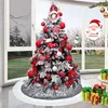 A decorated Christmas tree with presents underneath, set against a window with a view of a garden. Produktbild-Vorschau