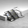 A smartphone screen protector and case are displayed on a concrete surface with a white block in the background. Produktbild-Vorschau