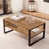 A coffee table in a living room setting, with books and candles on top. Voir les images du produit