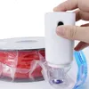 A hand is holding a white vacuum sealer pump next to a spool of red filament, which is partially enclosed in a vacuum bag. Náhľad obrázku produktu