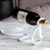 A wine bottle is suspended horizontally by a rope, creating a magical effect. Produktbild-Vorschau