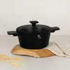 A black pot with a lid sits on a wooden board, with wheat stalks and a cloth nearby. Náhled obrázku produktu