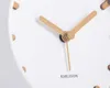 A close-up view of a white analog clock with wooden hands and hour markers. Anteprima dell’immagine prodotto