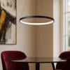 A modern dining area with a black pendant light hanging over a glass-top table and red chairs. Anteprima dell’immagine prodotto