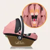 A pink baby car seat with a close-up inset showing the harness system. Náhled obrázku produktu