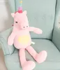A pink plush unicorn toy sits on a light blue armchair. Produktbild-Vorschau