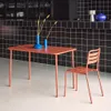 A terracotta metal garden table and chair set is shown in a modern setting with a black tiled backsplash. Produktbild-Vorschau