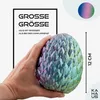 A hand holding a dragon egg with text overlays indicating size and branding. Produktbild-Vorschau
