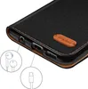 A close-up view of the bottom edge of a black flip phone case, showing ports and a small leather tag with a logo. Anteprima dell’immagine prodotto