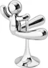 A chrome-plated bottle opener shaped like a person in a yoga pose, mounted on a stand. Náhľad obrázku produktu