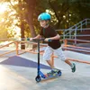 A young boy is riding a scooter in a skate park. Náhľad obrázku produktu