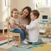 A mother and two children playing doctor in a brightly lit room. Anteprima dell’immagine prodotto