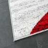 A close-up view of a rug with a geometric pattern, showing the texture and colors. Voir les images du produit