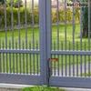 A close-up shot of a black metal bolt latch with a wooden handle attached to a gray metal gate, with a green lawn in the background. Náhled obrázku produktu