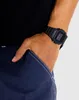 A close-up shot of a person's wrist wearing a black digital watch. Produktbild-Vorschau