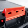 A close-up of an orange clip attached to a black organizer. Náhled obrázku produktu