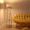 A floor lamp with shelves next to a yellow couch in a room. Podgląd zdjęcia produktu
