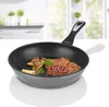 A frying pan with food inside, placed on a white surface with a blurred kitchen background. Produktbild-Vorschau