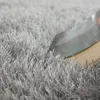 A close-up view of a shaggy rug with a book resting on it. Produktbild-Vorschau