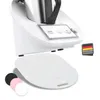 A white kitchen appliance with a touchscreen display and a white accessory underneath. Several colored circles are shown in the bottom left corner. Produktbild-Vorschau
