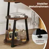 A round, multi-tiered side table with bottles and glasses on it, with text overlays highlighting its features. Podgląd zdjęcia produktu
