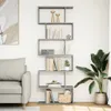 A gray bookshelf with books and decorative items in a living room setting next to a sofa and a plant. Anteprima dell’immagine prodotto