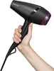A hand holding a black hairdryer with purple accents. Náhled obrázku produktu
