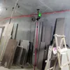 A construction or renovation site with building materials and a laser leveling tool. Náhled obrázku produktu