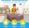 A young boy is playing with building blocks on a folded mattress in a child's room. The room has shelves with storage bins, a stuffed animal, and decorative clouds and stars on the wall. There are also three circular icons with text at the bottom of the im Produktbild-Vorschau