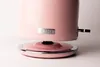 A close-up shot of the base of a pink Haden kettle, showing the brand logo and the power base. Produktbild-Vorschau