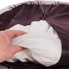 A hand is shown holding a white fabric inside a purple dog bed. Produktbild-Vorschau