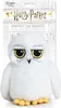 A plush toy owl, likely Hedwig from Harry Potter, is shown against a background that resembles a newspaper clipping. Produktbild-Vorschau