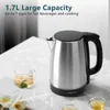 A stainless steel electric kettle with a black lid and handle is shown on a marble-like surface, next to a glass cup of tea with lemon and lime. Decorative white flowers are in the foreground. Produktbild-Vorschau