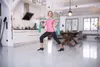 A woman is doing exercises with a resistance band in a modern apartment with a kitchen and dining area. Produktbild-Vorschau