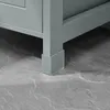 A close-up view of the bottom of a gray cabinet leg with a clear protective cap on the floor. Anteprima dell’immagine prodotto