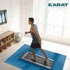 A man is exercising on a treadmill in a room with a TV and exercise ball. Produktbild-Vorschau