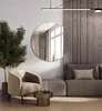 A modern living room with a round mirror, a chair, and a sofa. Produktbild-Vorschau