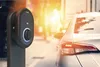 An electric vehicle charging station is shown next to a car on a street. Produktbild-Vorschau