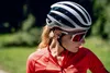 A woman wearing a cycling helmet and sunglasses, outdoors. Anteprima dell’immagine prodotto