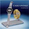Two Casio vintage watches, one silver and one gold, are displayed next to a smartphone against a blue gradient background. Produktbild-Vorschau