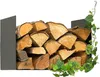 A stack of firewood is neatly stored in a black metal log holder, with green ivy vines growing around the right side. Produktbild-Vorschau