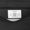 A close-up view of a label inside a black bag. Produktbild-Vorschau