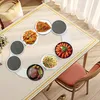 A dining table with a tablecloth and a rotating serving platter set with various dishes. Anteprima dell’immagine prodotto