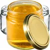 Three glass jars, one filled with golden honey and its lid slightly ajar, with two empty jars behind it. Produktbild-Vorschau