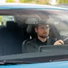A man driving a car, with a dashcam visible on the windshield. Produktbild-Vorschau