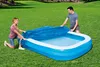 Two people are covering an inflatable pool with a blue tarp on a grassy lawn. Produktbild-Vorschau