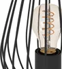 Close-up view of a vintage-style table lamp with a black metal cage and a visible Edison-style light bulb. Anteprima dell’immagine prodotto